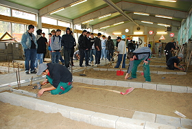 Das Bild zeigt eine Schulklasse beim Rundgang durch die Halle der Straßenbauer.