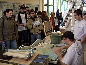 Das Bild zeigt eine Schulklasse und die Fliesenleger bei ihrer Arbeit!