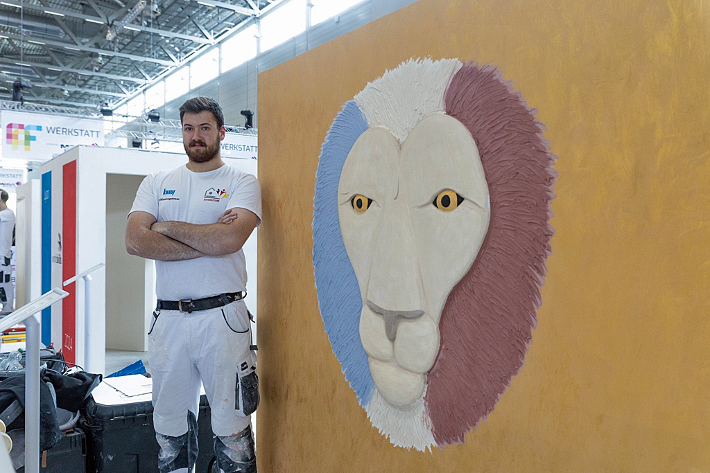 Lukas steht neben seiner Wand mit der "Freien Gestaltung"